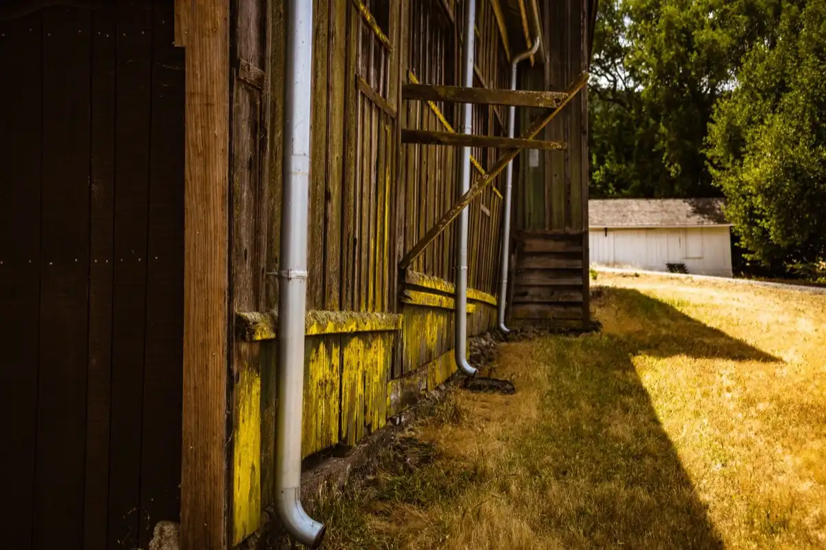 Roof edge, fascia and downspout on a house in El Monte, CA, where drip edge carries runoff into the gutter